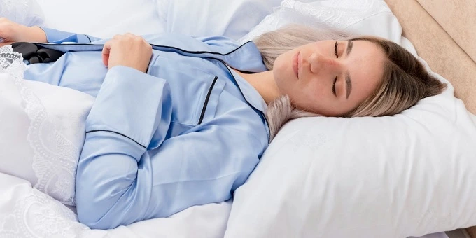 alvászavar - fiatal nő pizsamában békésen alszik